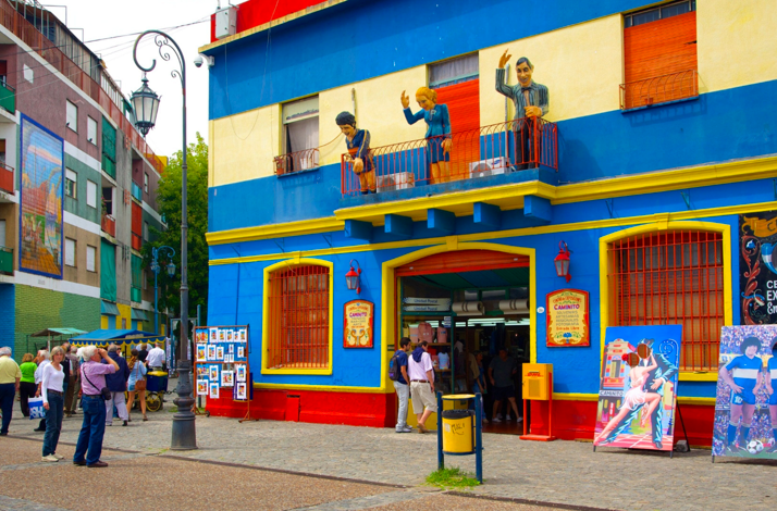 Vibrant Caminito building with street art and traditional figures showcasing Buenos Aires' cultural heritage.