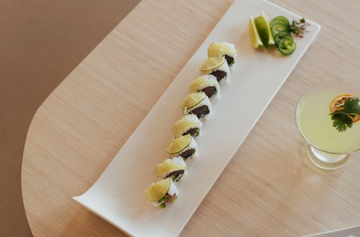 A sushi platter features scallop jalapeño rolls garnished with fresh lime slices served Zen Sushi.