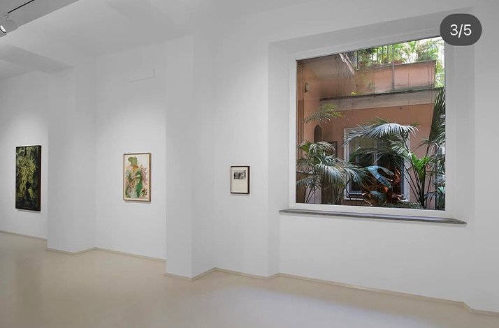 Brightly lit contemporary art gallery with framed modern artworks displayed on white walls and a minimalist design.