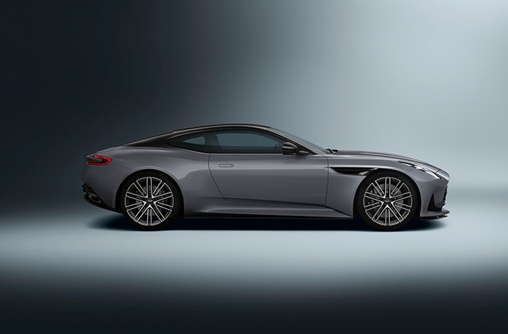 Sleek gray sports coupe in side profile on a dark gradient background.