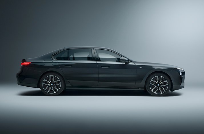 Dark grey BMW i7 luxury sedan in clean side profile, available as a premium SIXT rental option for Mastercard World Elite cardholders.