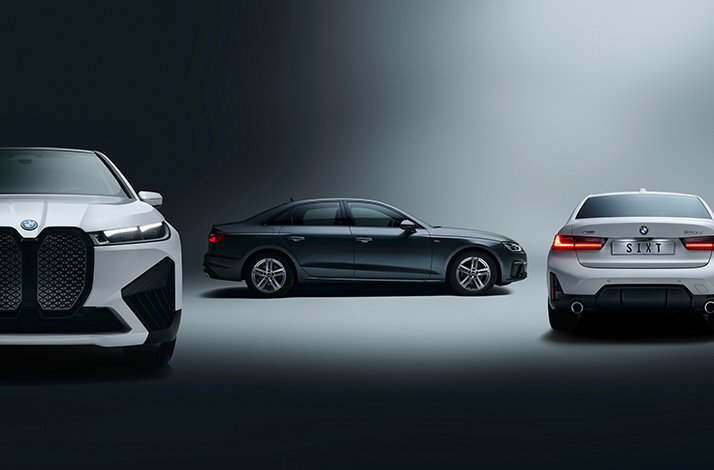 White BMW iX SUV front, dark grey Audi A4 sedan in profile, and white BMW sedan rear bearing a 'SIXT' plate, representing SIXT's Platinum fleet.