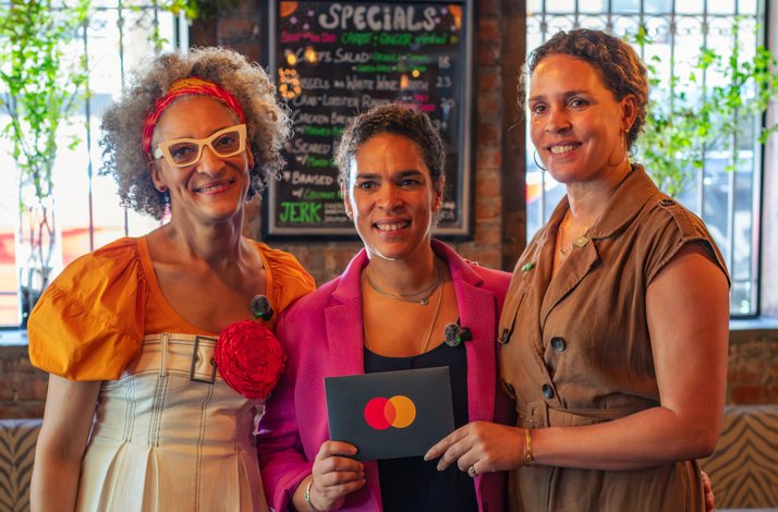 From the left: Top Chef Carla Hall and Co-owners of The Edge Harlem, Justine and Juliet, together whilst holding a Mastercard card.