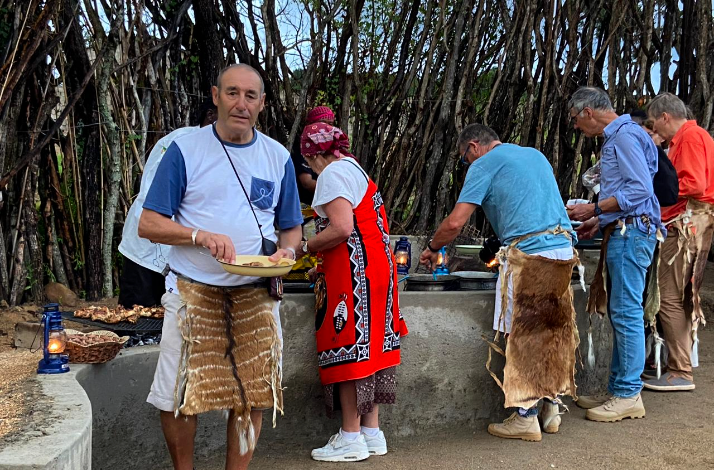 Visitors in traditional Nguni attire serving food at a buffet in Hazview.