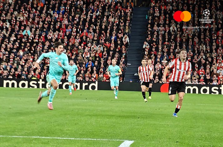 Players in action on pitch during Athletic Club v Sporting CP UEFA Champions League League Phase match before a packed stadium.