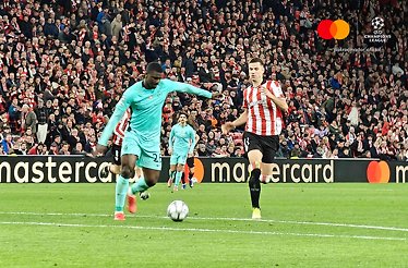 Sporting CP player in teal kit controlling ball under pressure from Athletic Club defender in UEFA Champions League match.
