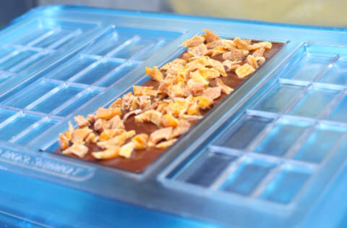 A bespoke handcrafted chocolate bar with toppings in a mold at the '57 Chocolate factory.