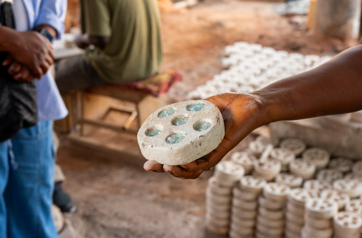 A craftsman holding a clay mold filled with crushed glass before firing at Cedi Bead Factory in Ghana.