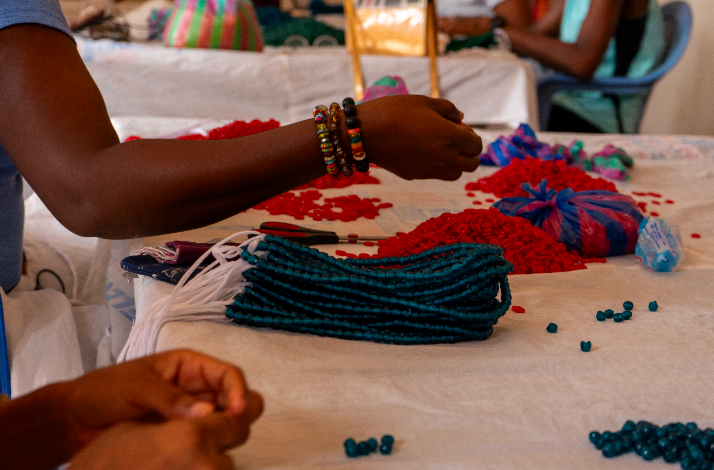 Visitors assembling colorful bracelets using recycled glass beads during a workshop at Cedi Bead Factory in Ghana.