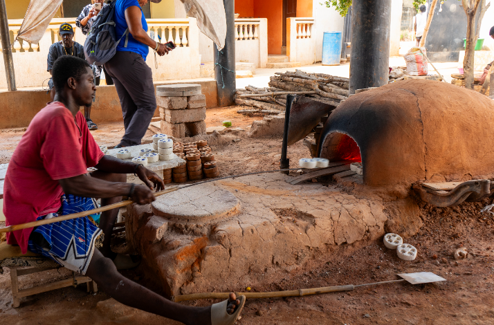 A craftsman firing recycled glass beads in an earthen kiln at Cedi Bead Factory in Ghana.