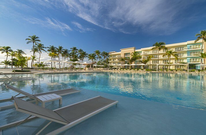 Westin Punta Cana resort pool with loungers and palm trees.