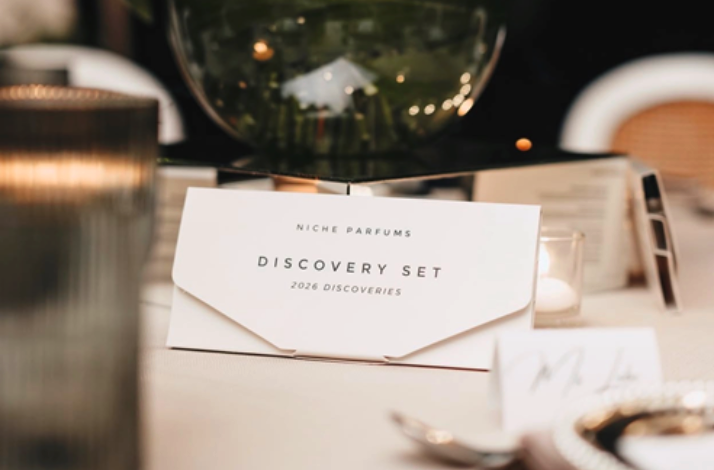 'Niche Parfums Discovery Set 2026 Discoveries' card displayed on an elegantly set dining table at Chef Black's sensory event.