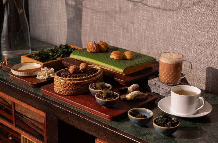 Curated tasting display of traditional Malaysian snacks, coffee, tea, and spices arranged on wooden boards at Akar restaurant.