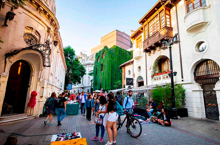 Pedestrian street in Santiago's heritage district with local shops, street activity, and historic architecture, showcasing the city's vibrant urban life and culture.