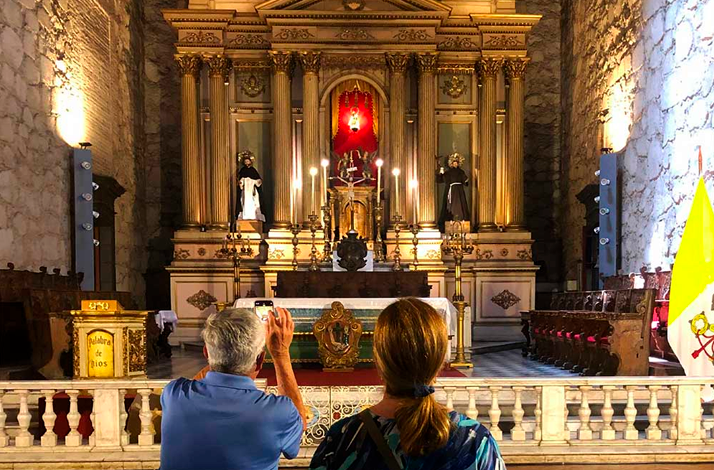 Visitors admiring the historic interior of a colonial church in Santiago, discovering Chile's religious heritage and architectural traditions during a guided cultural tour.