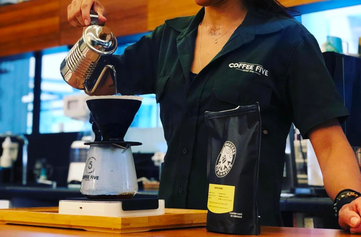 Barista demonstrating specialty coffee brewing techniques at Coffee Five in Rio de Janeiro.