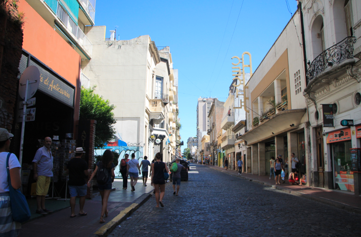 Historic street in San Telmo lined with shops, cafés, and classic Buenos Aires architecture.
