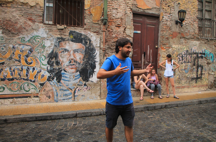 Local guide sharing stories of Buenos Aires' cultural heritage beside colorful street art.
