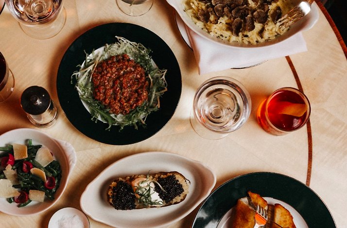 Aerial view of Mediterranean dishes and cocktails arranged on a dining table at Casa Cruz New York.