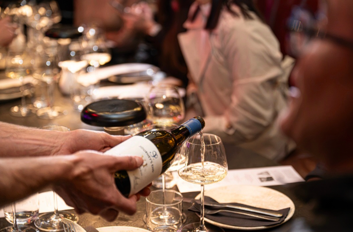 Wine being poured at the table during the dinner.