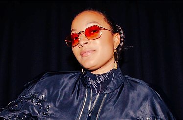 Promotional banner for artist Nubya Garcia in navy blue outfit.