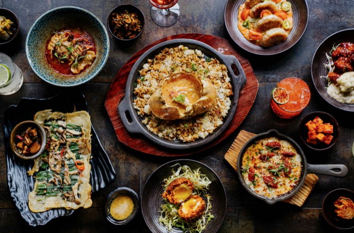 Overhead spread of Korean-inspired shared plates, skillet rice, and cocktails at Pace NYC