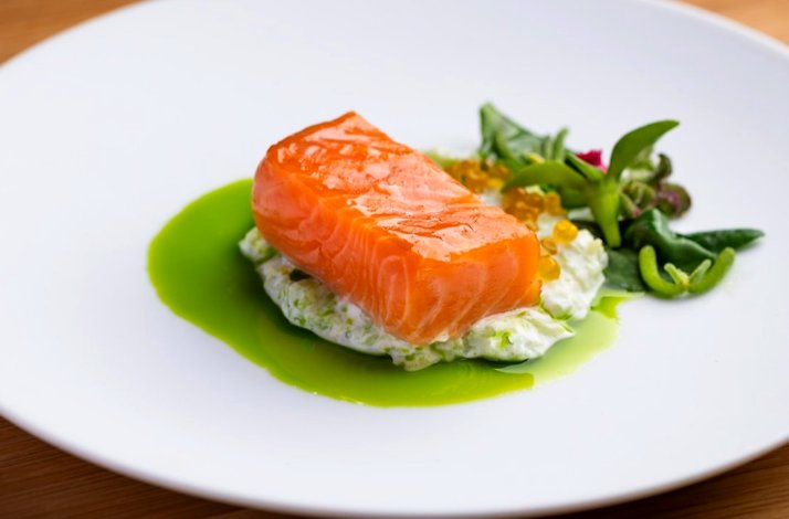 Glazed salmon fillet set on creamy herb base with bright green sauce, and golden roe at Jacaranda.