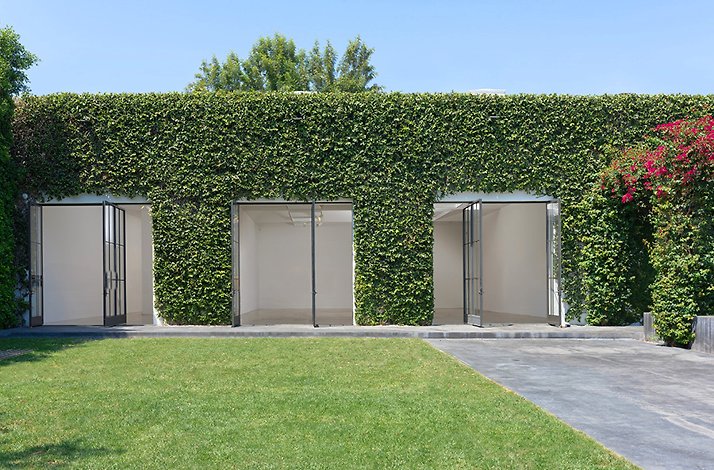 Pace Gallery Los Angeles exterior showing ivy-covered facade with three open steel-framed gallery bays and green lawn.