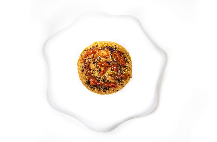 Grain-based dish garnished with tomatoes and walnuts, elegantly plated at A'Cuncuma, Palermo.