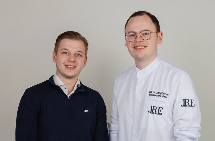 Two Restaurant Fris team members pose for a portrait, one in a chef jacket and one in a dark sweater