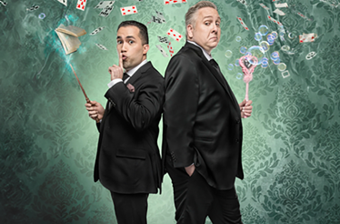 Joel Acevedo and Steve Kradolfer, the magicians back-to-back with wand, bubbles, and flying playing cards.