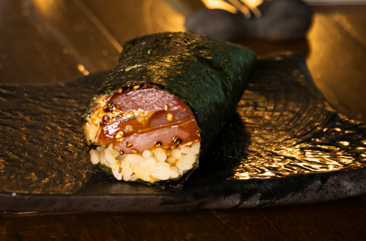 Freshly prepared sushi rolls filled with premium fish and avocado, crafted during a hands-on culinary experience inside an intimate restaurant kitchen.