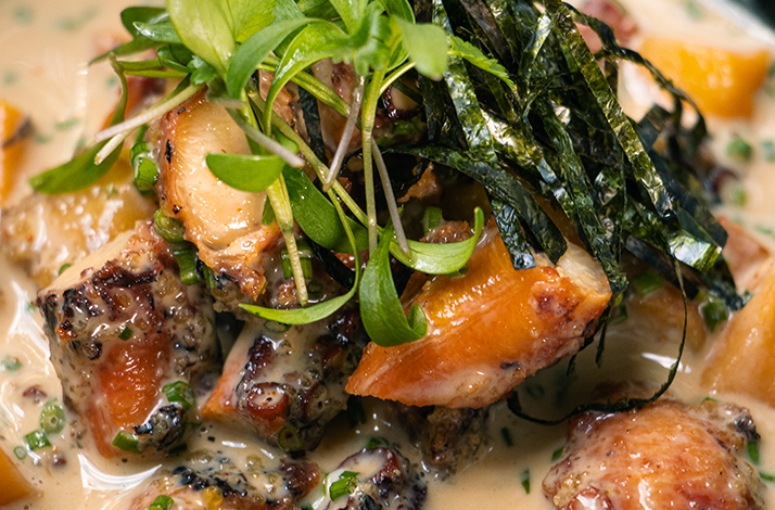 Signature seafood dish prepared with locally sourced fish, showcasing artisanal fishing ingredients and Asian-inspired flavors, finished with fresh herbs and seaweed.