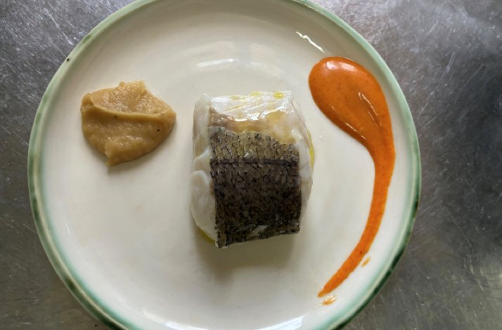 Plated fish fillet with crispy skin, orange coulis and golden puree served at O Balado restaurant.