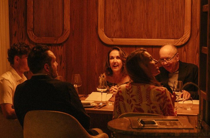 Group enjoying dinner and wine in an intimate wood-paneled private dining space at Eloise.