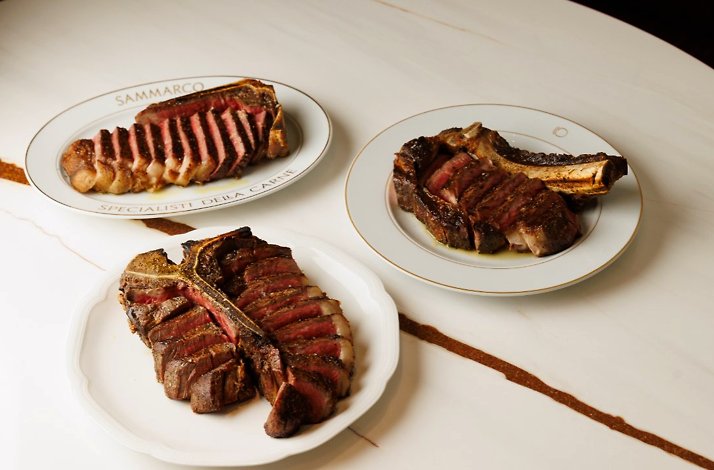 Expertly sliced cuts of dry-aged steak served on branded plates from Sammarco.