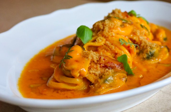 Spaghetti with mussels, prawns, and toasted breadcrumbs in a rich saffron-tomato broth, served at Osteria Giulia.
