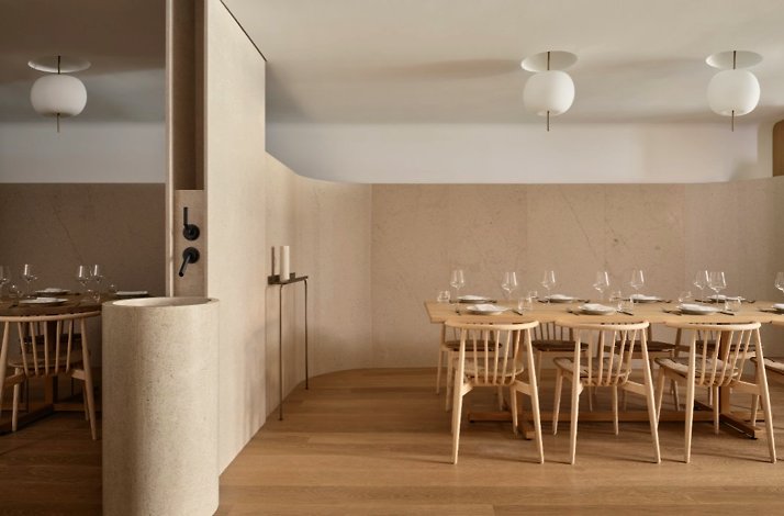 Osteria Giulia's private dining room with a long communal table, spindle chairs, and globe pendant lights.