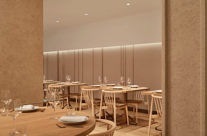 Osteria Giulia's intimate dining room featuring light wood tables, linen napkins, and soft ambient lighting.