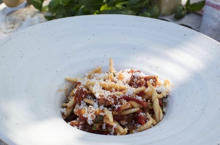 Plated trofie pasta with tomato sauce and grated cheese at a Dublin Cookery School culinary workshop.