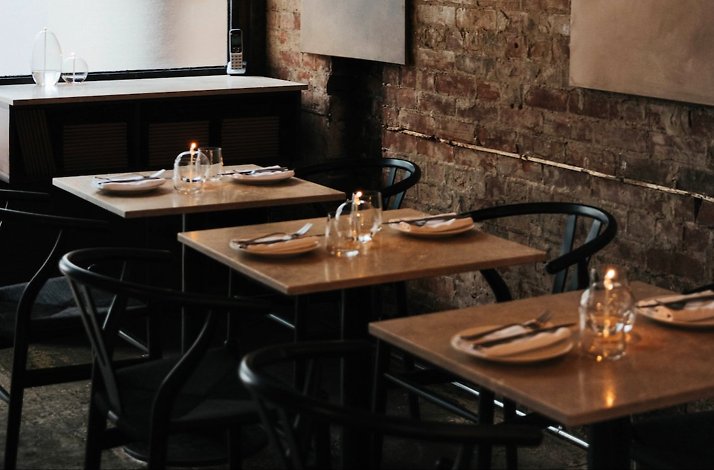 Tables for 2 set at the wall in Liliana restaurant.