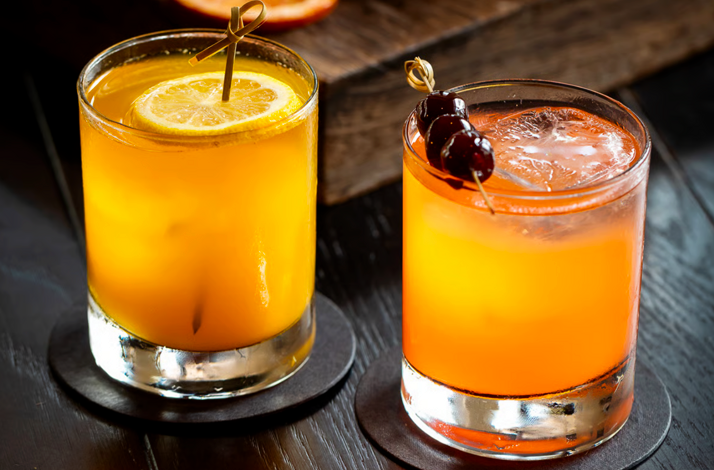 Vibrant signature cocktails garnished with citrus and cherries.