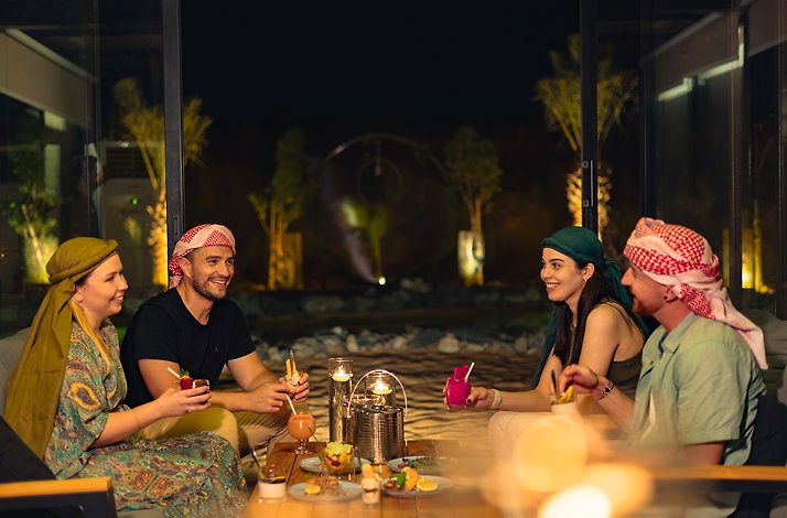 Safari participants at the Dubai Desert Conservation Reserve enjoying a meal at their campsite.